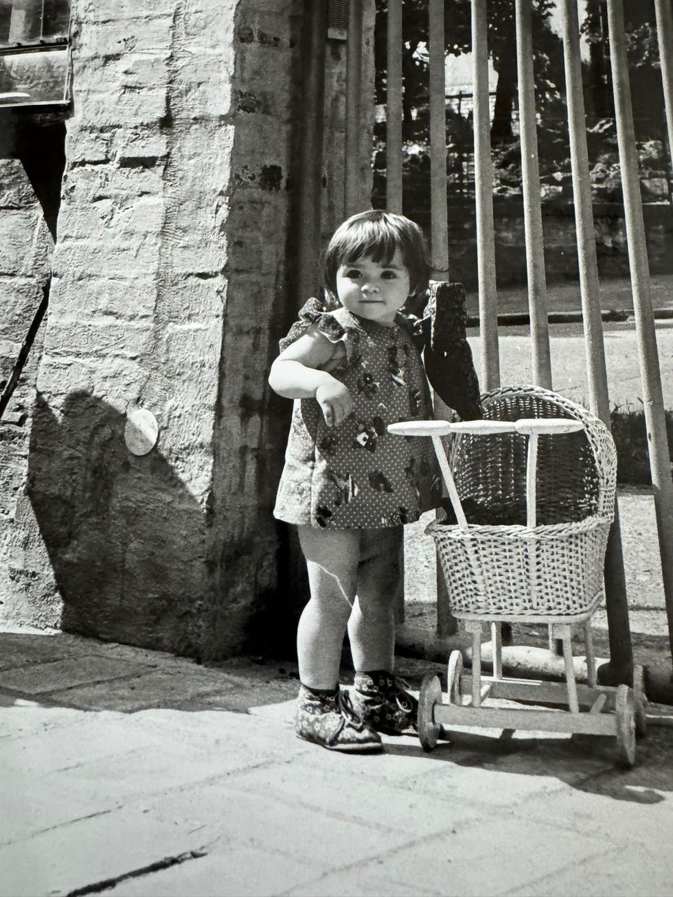 Petra as a little girl with a doll pram